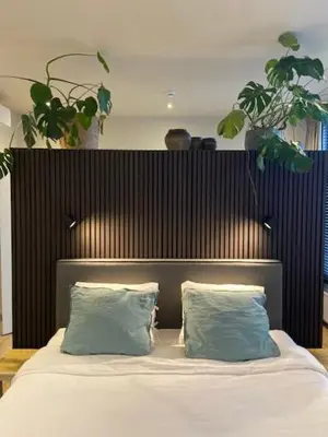 a bed with two blue pillows in a bedroom at B&B Toast Hoogstraten in Hoogstraten
