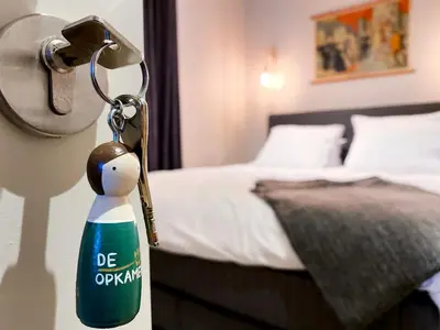 a key chain with a penguin next to a bed at B&B Toast Hoogstraten in Hoogstraten