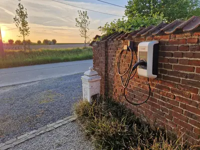 a fire hydrant next to a brick wall with a pay phone at Muntershof in Velzeke-Ruddershove