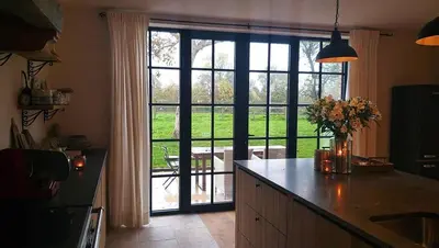 a kitchen with an open door to a patio at Muntershof in Velzeke-Ruddershove