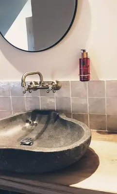a stone sink in a bathroom with a mirror at Muntershof in Velzeke-Ruddershove