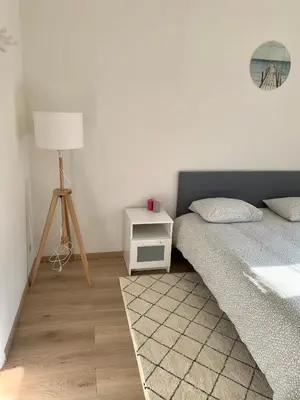 a bedroom with a bed and a nightstand with a lamp at Charming Europarlament Resedence in Brussels