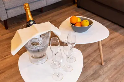 a table with wine glasses and a bowl of fruit at B&B Steendam 66 in Ghent