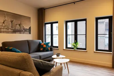 a living room with a couch and windows at B&B Steendam 66 in Ghent