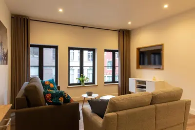 a living room with a couch and a tv at B&B Steendam 66 in Ghent