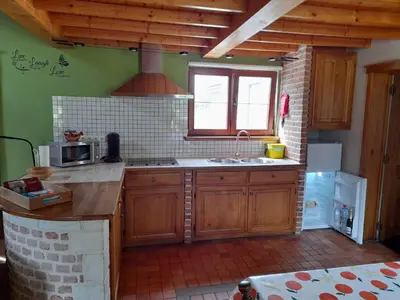 a kitchen with wooden cabinets and a sink and a window at Vakantiehuisje 't Morehof in Oosterzele