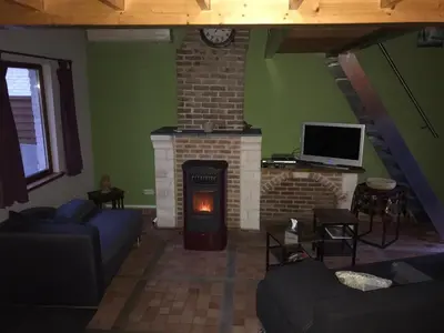 a living room with a fireplace and a tv at Vakantiehuisje 't Morehof in Oosterzele
