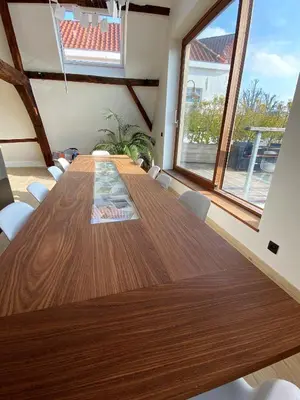 a dining room table with white chairs and a large window at Burgstraat 17 Apartment in Exclusive Patrician House in Medieval Ghent in Ghent