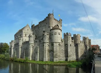 a large castle sitting on the side of a river at Burgstraat 17 Apartment in Exclusive Patrician House in Medieval Ghent in Ghent