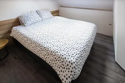 a bedroom with a bed with a black and white comforter at Logies De blauwe regen in Beveren