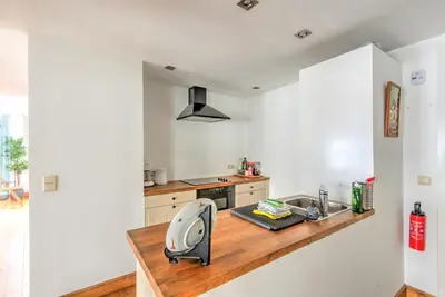 a kitchen with white walls and a wooden counter at Tempel Cathedral Lodge in the Heart of Antwerp in Antwerp