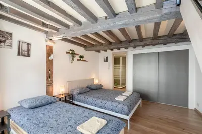 a bedroom with two beds and a wooden ceiling at Tempel Cathedral Lodge in the Heart of Antwerp in Antwerp