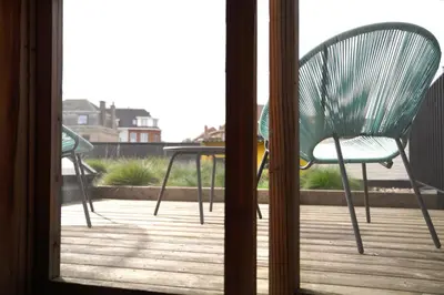 a green chair and a table on a deck at Well-situated and Comfortable Home in Ghent