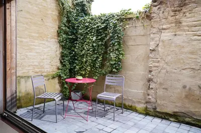 a red table and two chairs and a table and a wall at Well-situated and Comfortable Home in Ghent