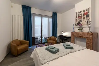 a bedroom with a bed and a fireplace and a desk at Fish Market Apartments in Brussels