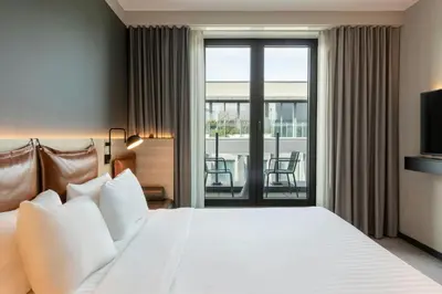 a hotel room with a bed and a balcony at Moxy Brussels City Center in Brussels