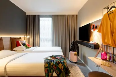 a hotel room with two beds and a television at Moxy Brussels City Center in Brussels