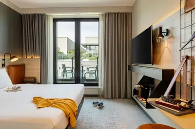 a hotel room with a bed and a large window at Moxy Brussels City Center in Brussels