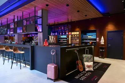 a bar with a suitcase and a guitar in a room at Moxy Brussels City Center in Brussels