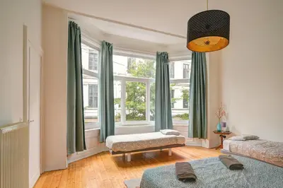 a living room with a large window with green curtains at The National Lodge in Antwerp