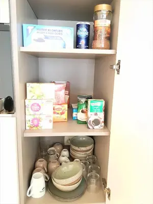 a cupboard filled with dishes and other food items at The National Lodge in Antwerp