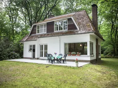 a small white house with a table and chairs at Westmalle Forest Garden Home in Zoersel