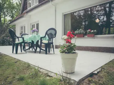 a patio with a table and chairs and a potted plant at Westmalle Forest Garden Home in Zoersel