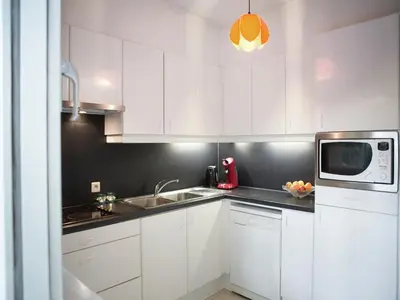 a white kitchen with white cabinets and a microwave at Westmalle Forest Garden Home in Zoersel