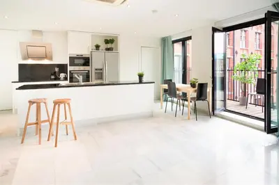 a kitchen and dining room with a counter and chairs at The Antwerp Marble Lodge in Antwerp