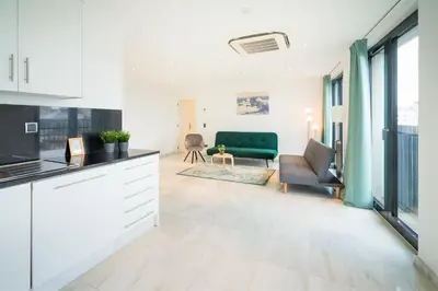a kitchen and living room with a green couch at The Antwerp Marble Lodge in Antwerp