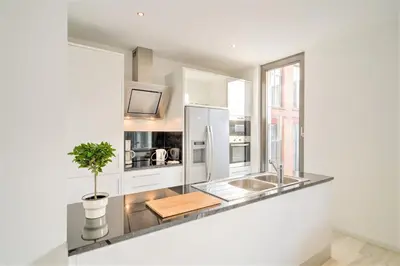 a kitchen with a sink and a refrigerator at The Antwerp Marble Lodge in Antwerp