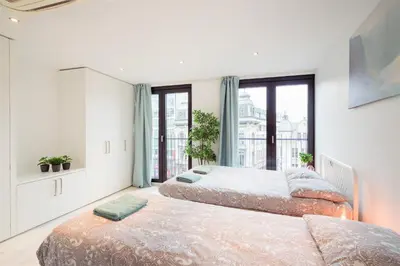 two beds in a room with a large window at The Antwerp Marble Lodge in Antwerp