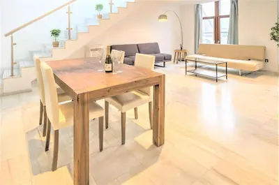 a dining room table and chairs in a living room at The Antwerp Marble Lodge in Antwerp