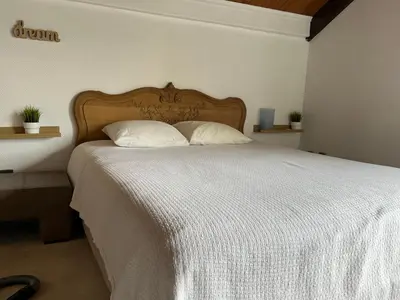 a bedroom with a large bed with white sheets and pillows at Aquavilla Bed & Breakfast in Willebroek