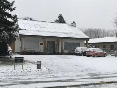 a house with two cars parked in the snow at Aquavilla Bed & Breakfast in Willebroek