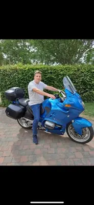 a man is standing next to a blue motorcycle at Aquavilla Bed & Breakfast in Willebroek