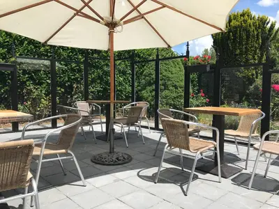 a patio with tables and chairs and an umbrella at Aquavilla Bed & Breakfast in Willebroek
