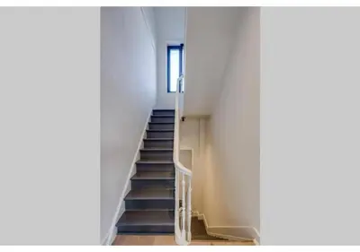 a staircase in a white building with a window at The Heart of Leuven in Leuven