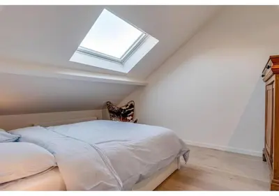 a bedroom with a bed and a skylight at The Heart of Leuven in Leuven