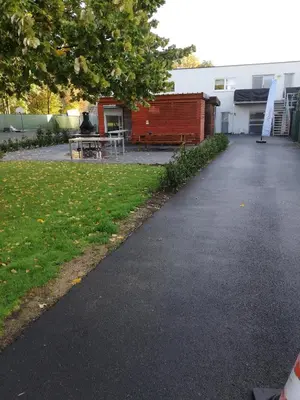 a walkway leading to a building with a table and a bench at NUVOLA HOUSE in Zottegem
