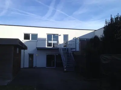 a white building with a staircase on the side of it at NUVOLA HOUSE in Zottegem