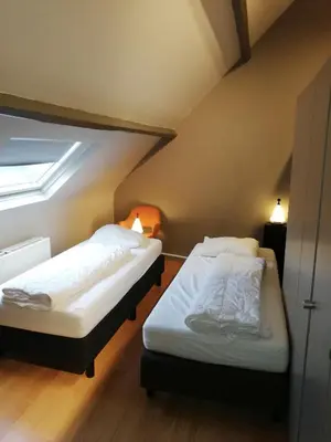 two beds in a room with a window at NUVOLA VILLA in Zottegem