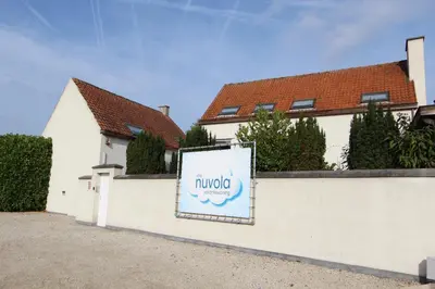a sign on a white fence in front of a house at NUVOLA VILLA in Zottegem