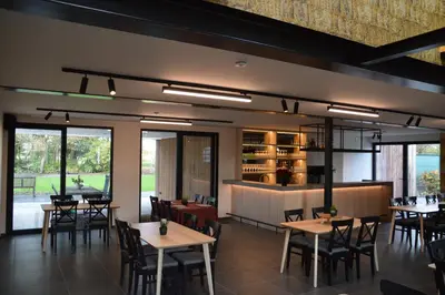 a restaurant with tables and chairs and a bar at B&B Tantine in Retie