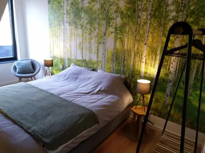 a bedroom with a bed with a tree mural at B&B Tantine in Retie