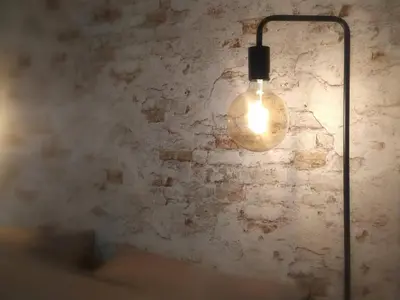 a light bulb hanging from a brick wall at B&B Tantine in Retie