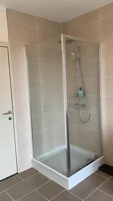 a shower with a glass door in a bathroom at Panda Stella in Zaventem