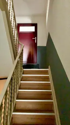 a stairway with a red door in a building at Panda Stella in Zaventem