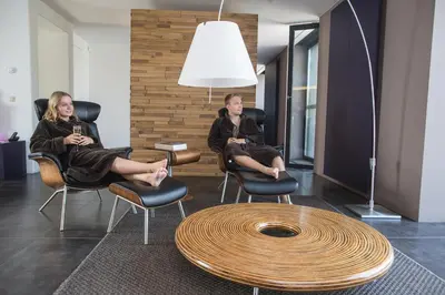 two women sitting in chairs in a room with a table at Loft Aan Het Water in Grobbendonk
