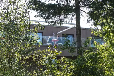 two people sitting on a balcony of a building at Loft Aan Het Water in Grobbendonk